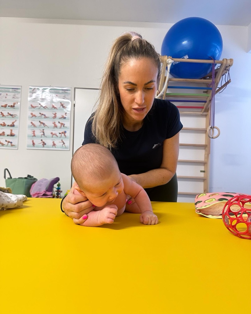 Fyzioterapeutka pri vyšetrení bábätka na žltom lehátku